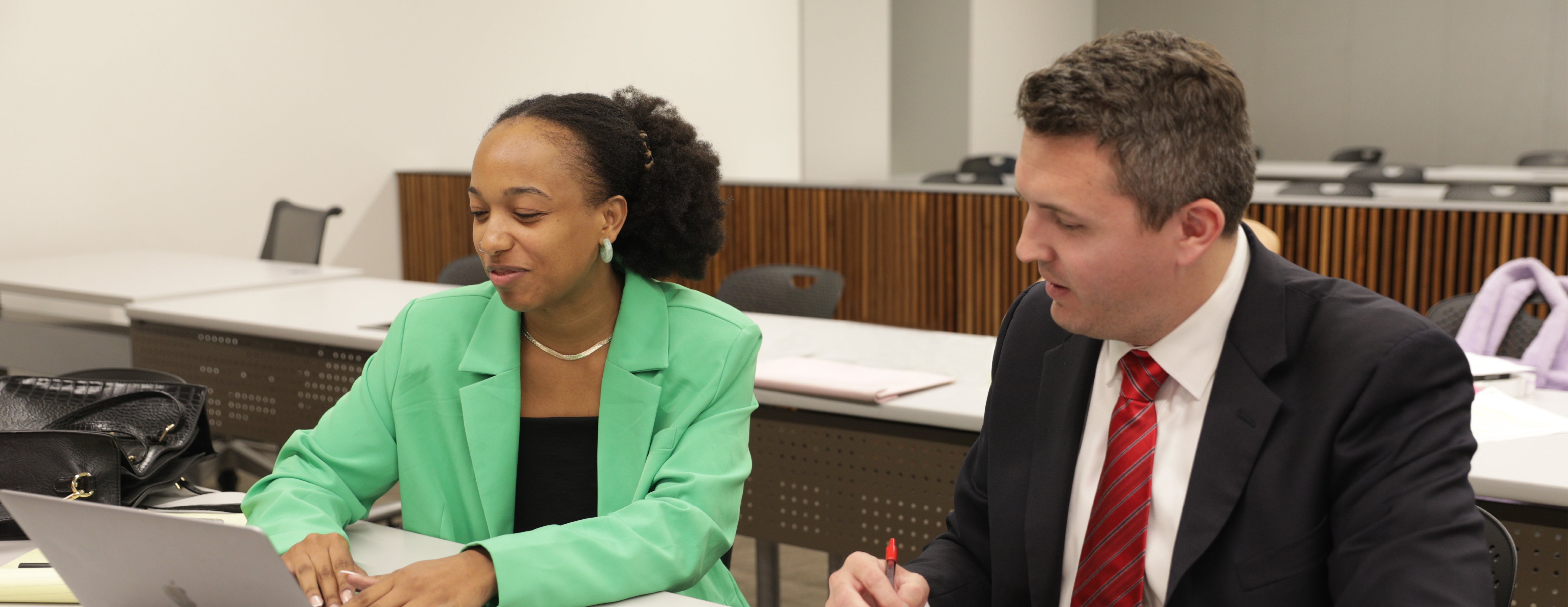 Two students discussing their strategies in Moot Court during a mock trial.