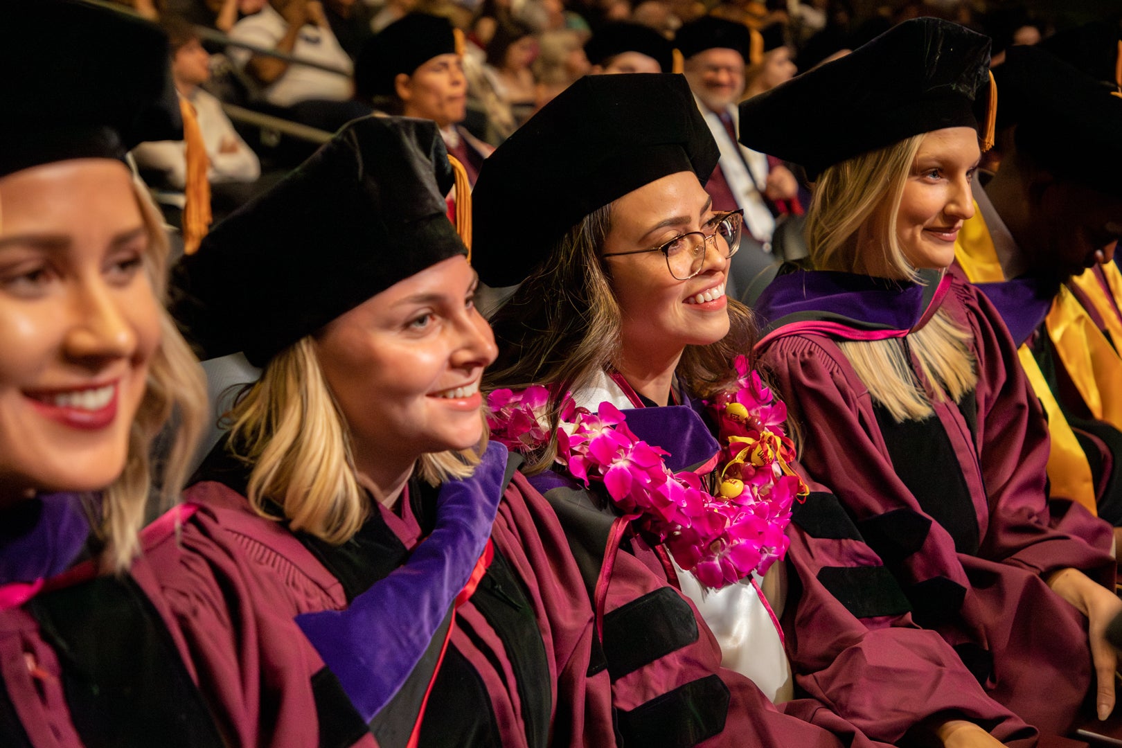 Four JD graduate students sitting during the Spring 2023 Convocation ceremony. 