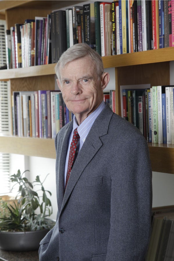 William C. Canby Jr. posing in front of law book in his office.