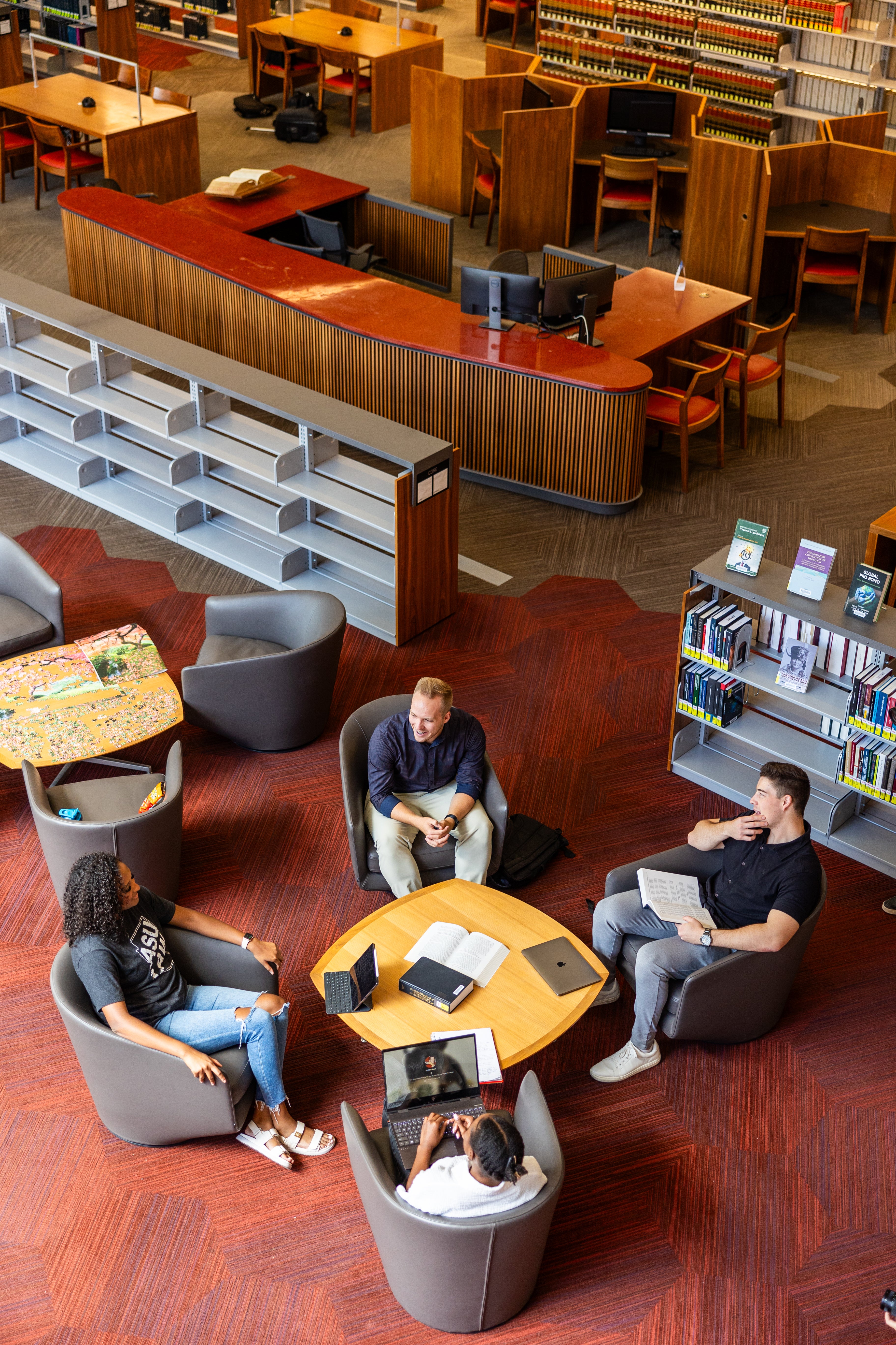 Four student working together while sitting in the ASU Law Library.
