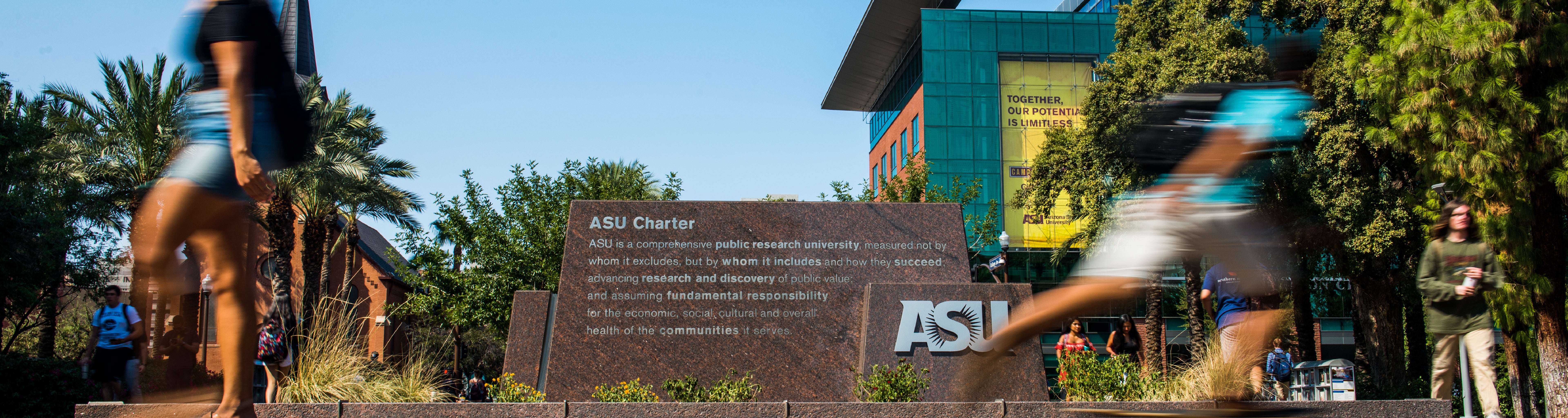 ASU Charter on statue in the Tempe campus. Students are walking by.