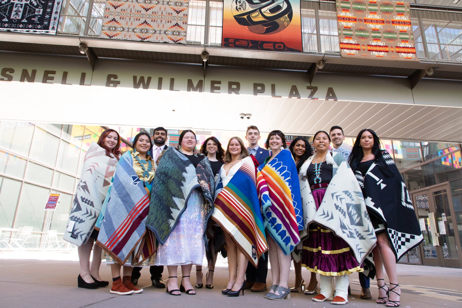 2024 Indian Legal Program graduates holding their ceremonial blankets in from on ASU Law.