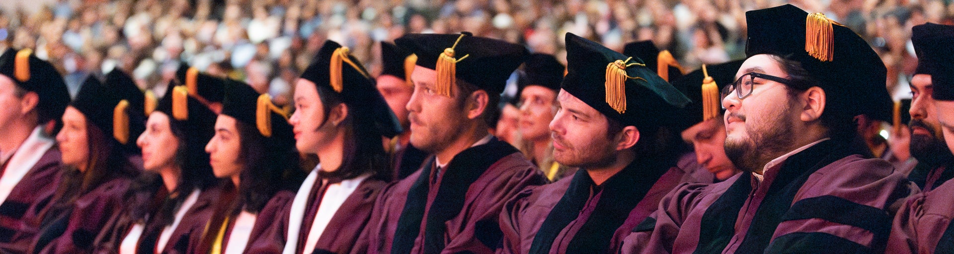 JD graduate students dressed in regalia, sitting together during the Spring 2024 Convocation ceremony.