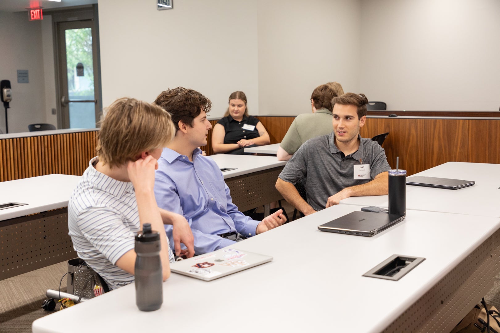 Three ASU Law students sitting together and talking in a classroom.