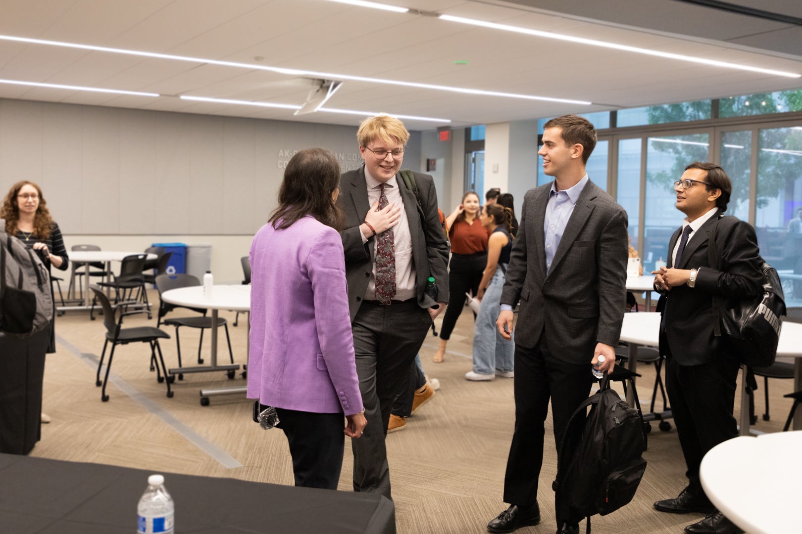 Federal Trade Commission Chair, Lina M. Khan talking with three ASU Law students in buisiness suits. 