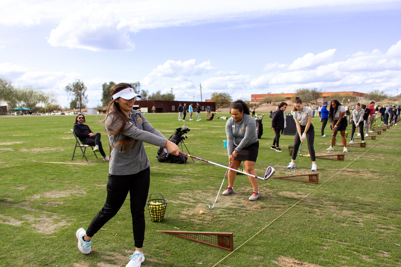 A group of ASU Law students swinging golf clubs at the golf range.