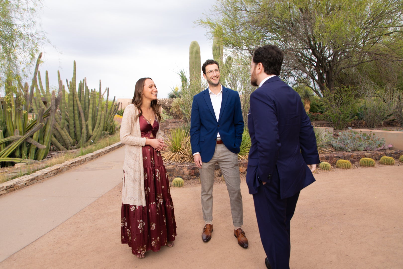 Three ASU Law students talking at the Phoenix Botanical Gardens surrounded by green cacti.