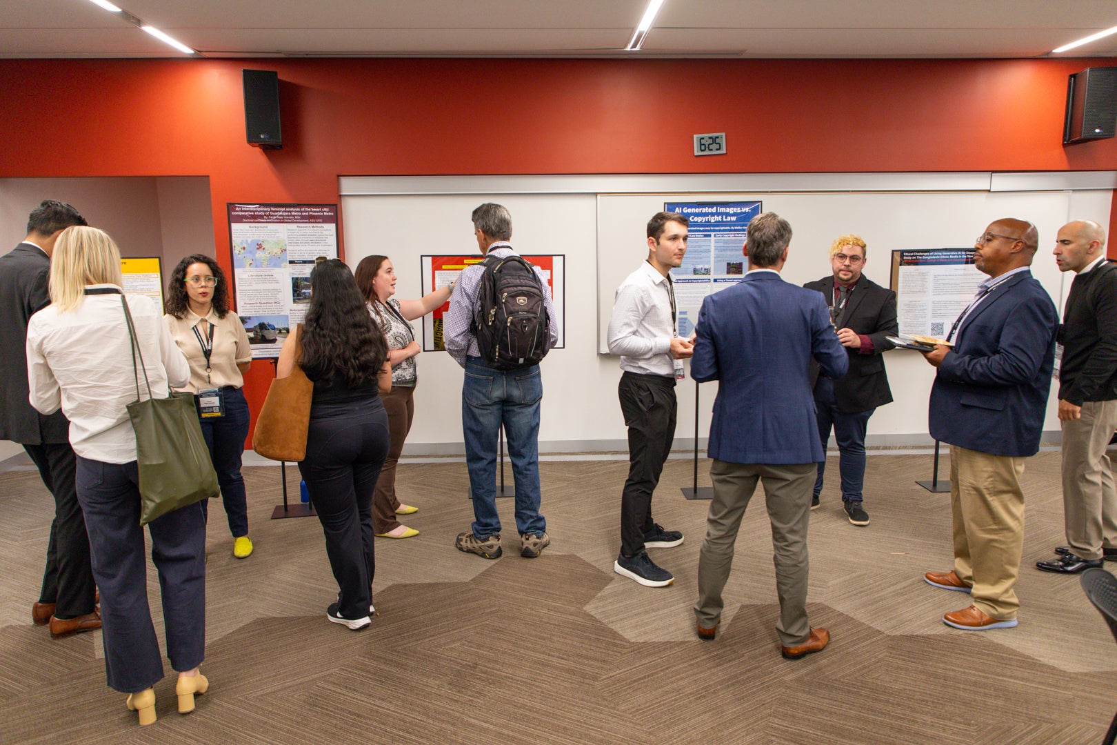 Law, Science and Technology students talking with professors in front of their student posters.