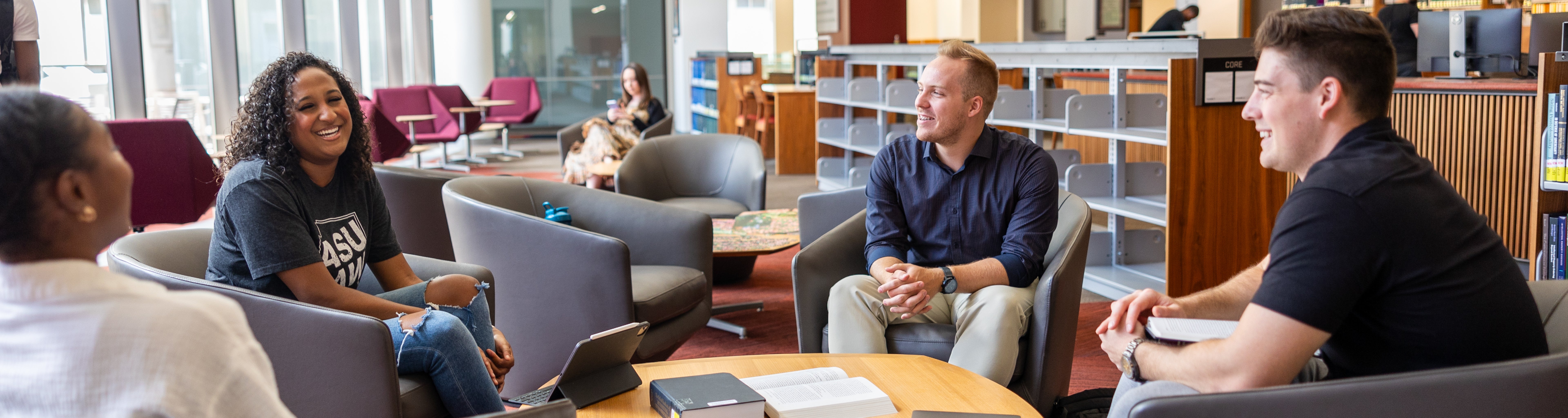 Sports Law and Business students sitting in the ASU Law library talking and laughing together.