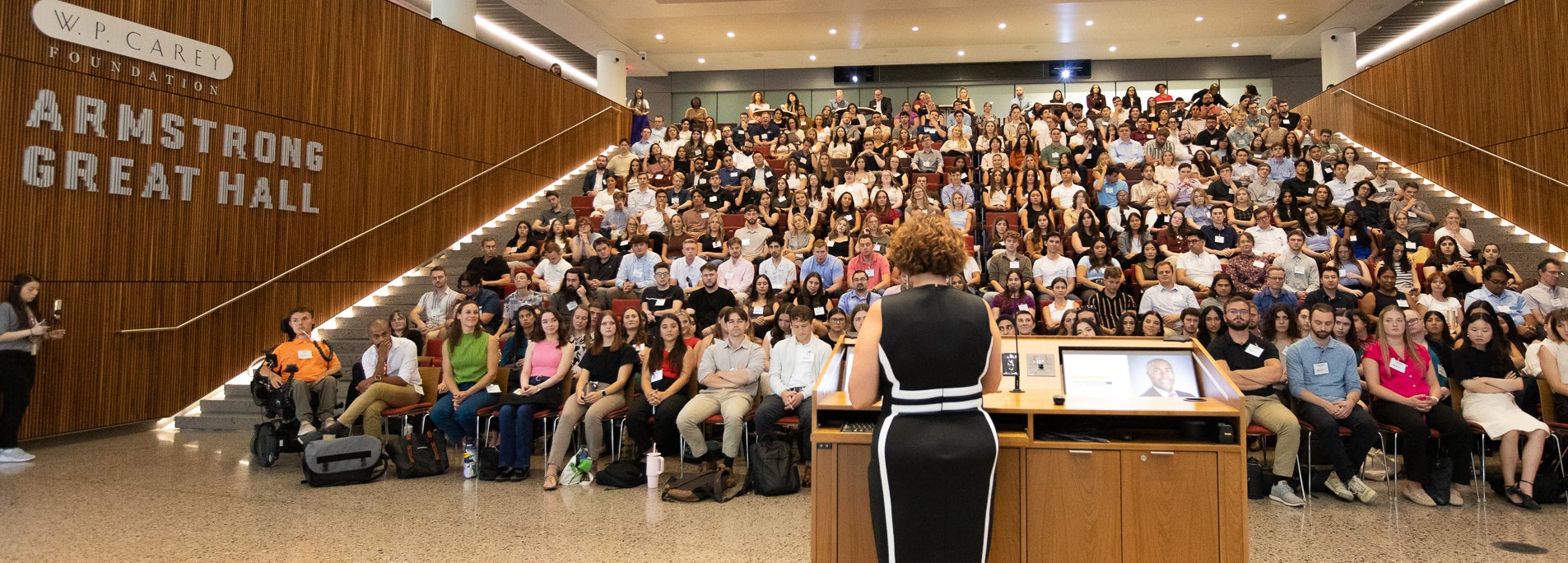 Dean Stacy Leeds welcoming new students in an auditorium for orientation.