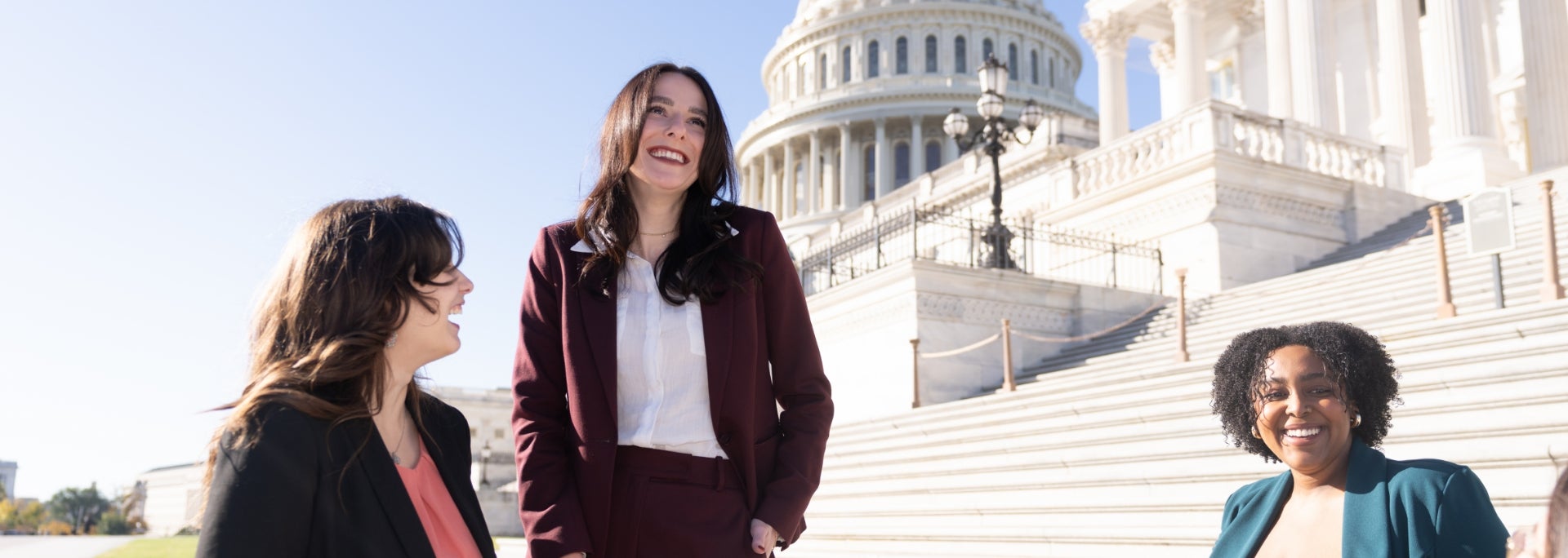 Three ASU Law students laugh together on the steps of the United States Capitol in Washington D.C.