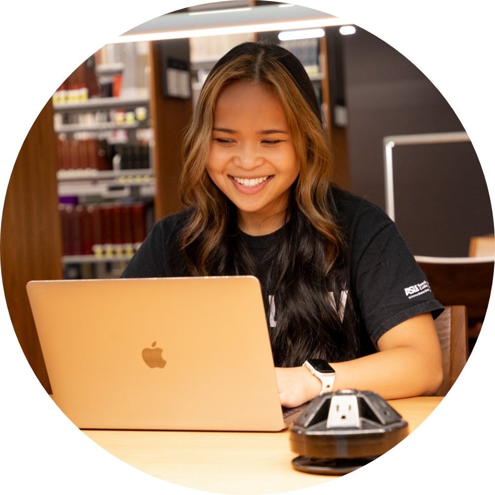 A student smiles while studying in the ASU Law Library