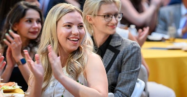 ASU Law students smile and laugh while attending their graduation ceremony.