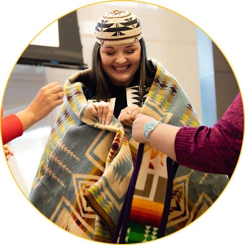 A student is wrapped in their blanket at the Spring 2025 ILP Blanket Ceremony