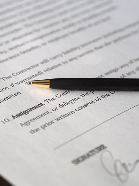 Pen sitting on a signed mock contract