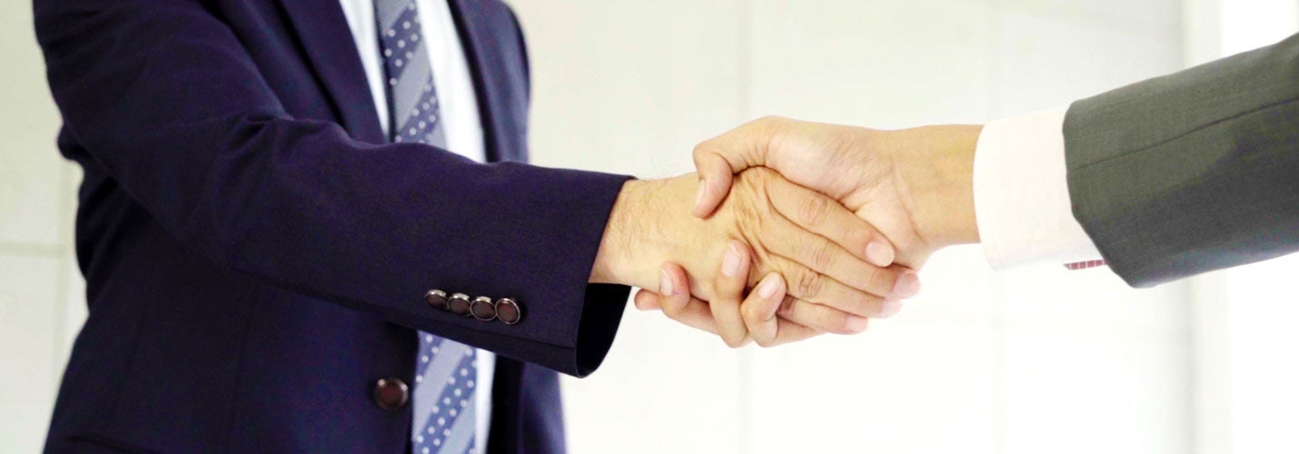 Two men in suits shaking hands