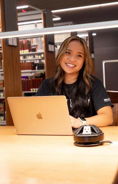 A student smiles while studying in the ASU Law Library