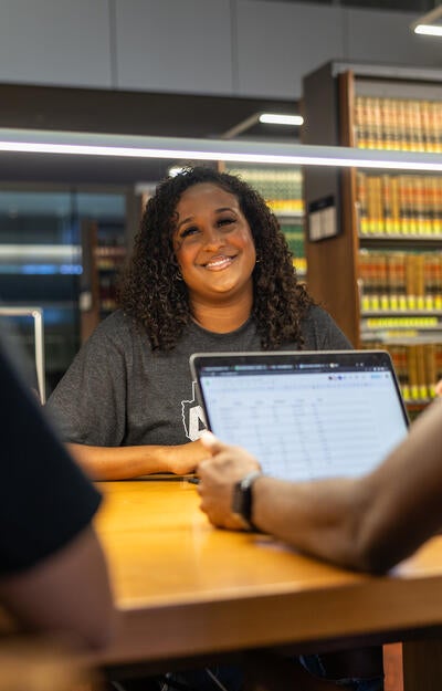 A student smiles while studying in the ASU Law Library