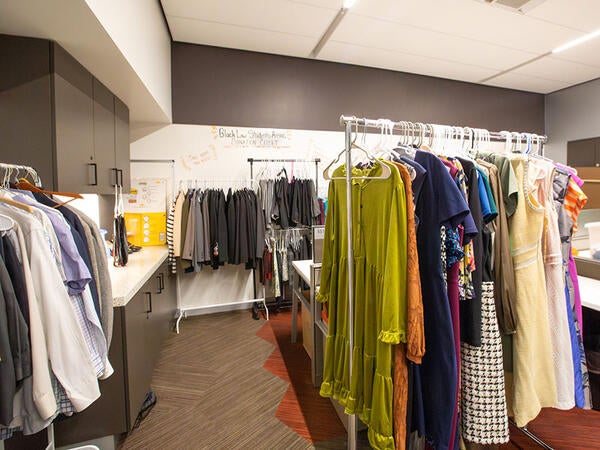 A law school room has been turned into a colorful closet, full of professional dresses and suits.