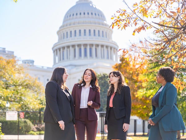 four women in front of building