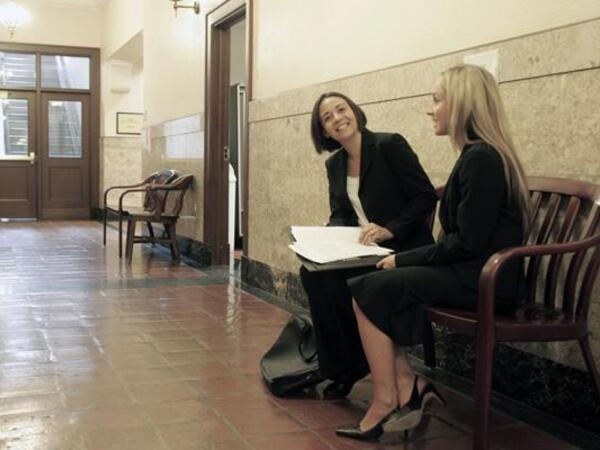 Prosecution Clinic - Lawyer and student conversing in hallway of courthouse