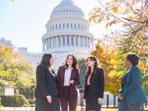 four women in front of building