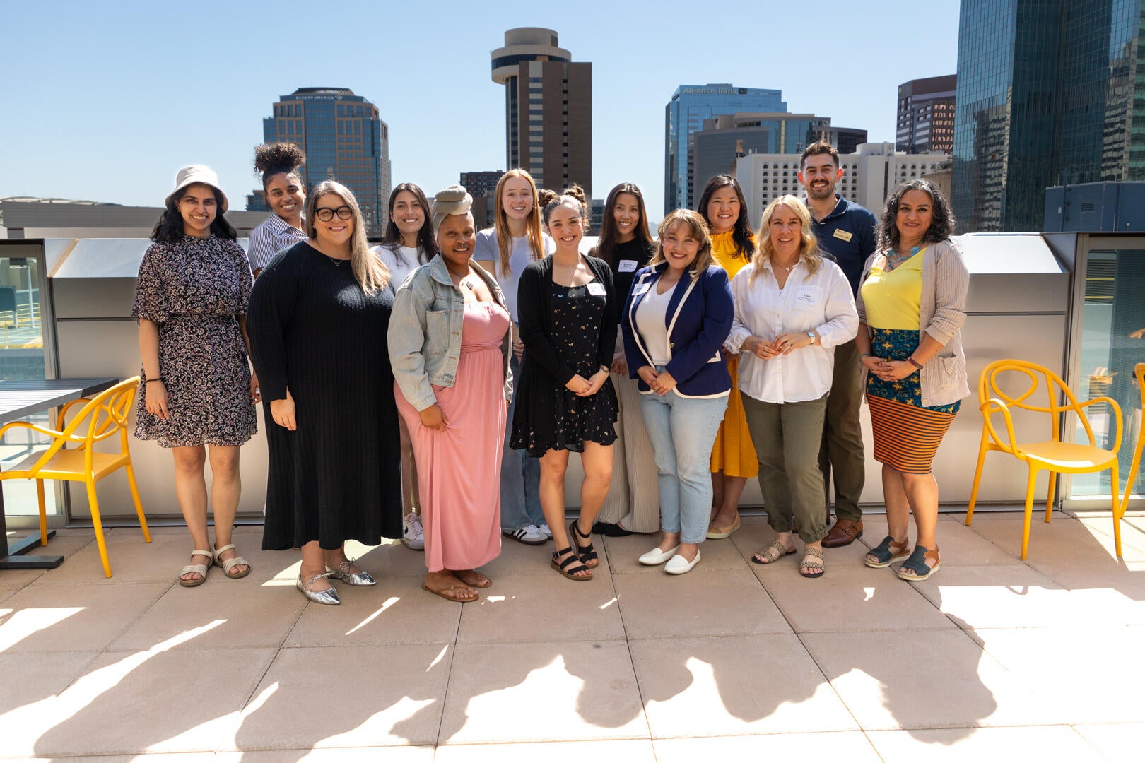 Students attending the AP Masters Lunch. They are posing outside on the balcony on a sunny day.